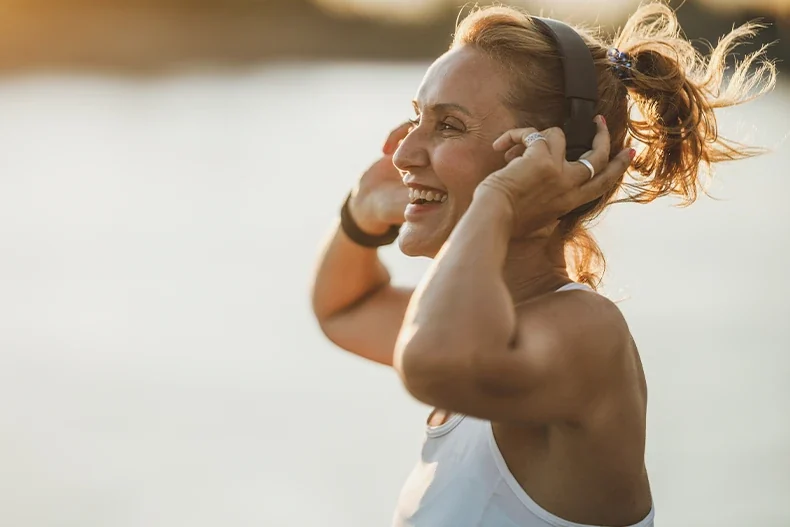 Mulher ao ar livre usando fones de ouvido — imagem ilustrativa